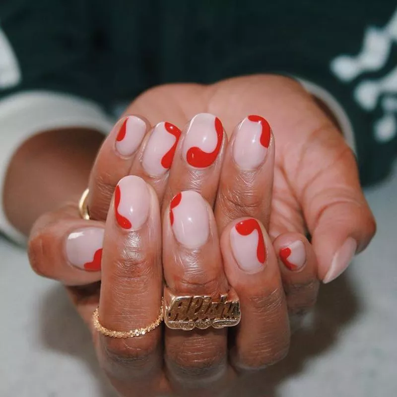 Milchige Maniküre mit fleckigem rotem Nageldesign