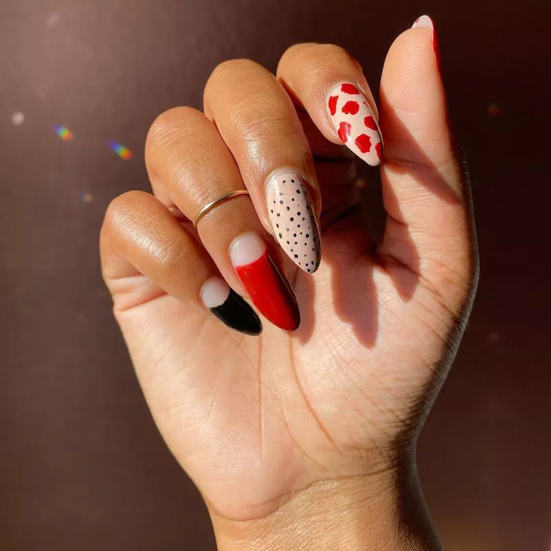 Beige, schwarze und rote Nägel mit gepunkteten, gefleckten und negativen Raumdesigns