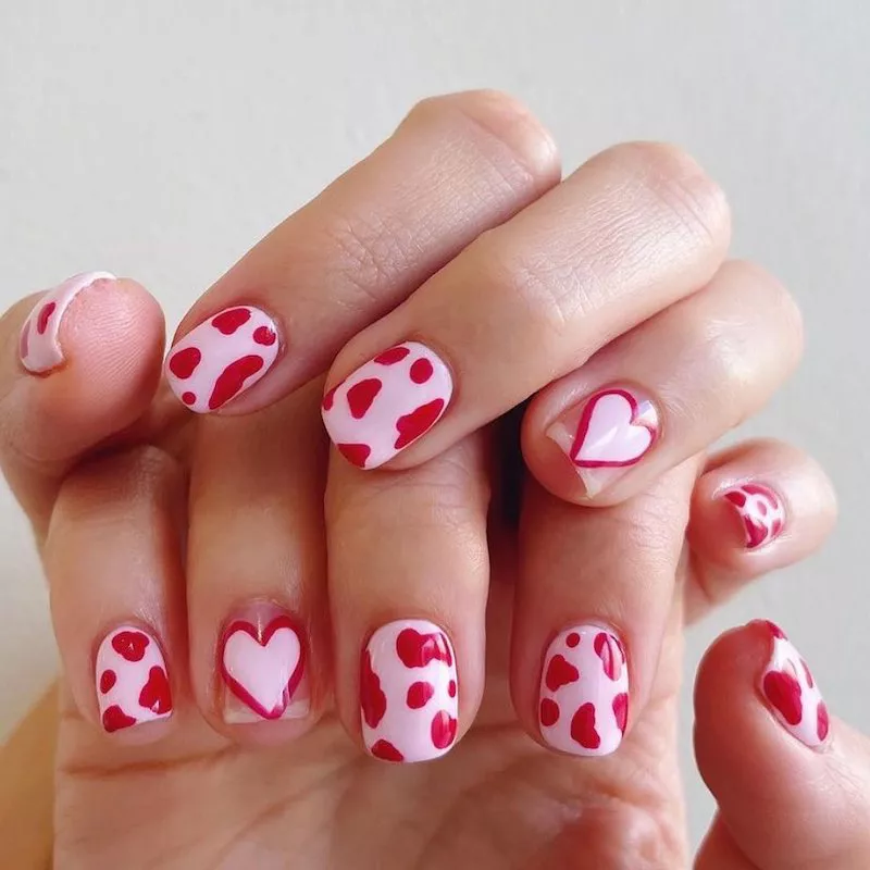Rosa und rote Nägel mit Kuh-Print und Herz-Designs