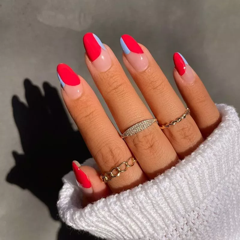 Negative Space-Maniküre mit leuchtend roten und pastellblauen Split Tips