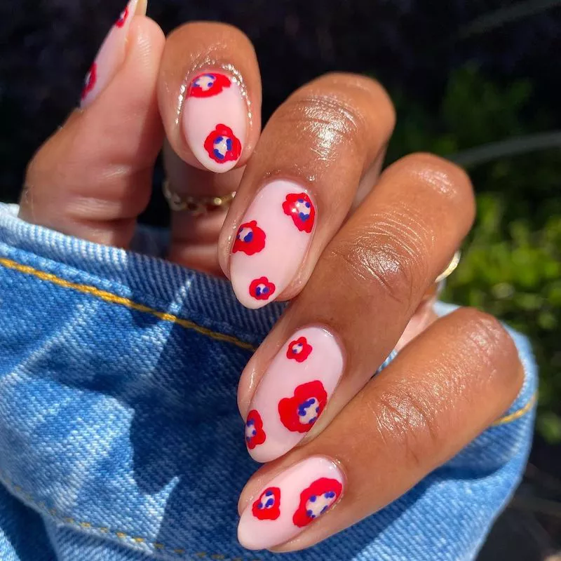 Pfirsichfarbene, neutrale Nägel mit rot-blauem Mohn-Design
