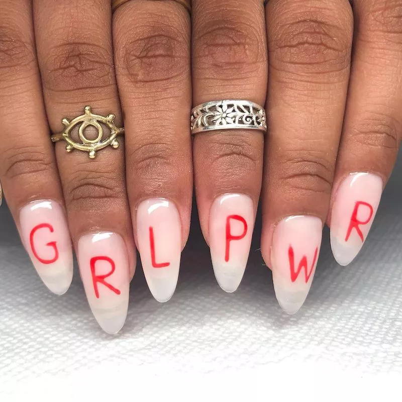 Durchscheinende weiße Acrylnägel mit roter „GRL PWR“-Aufschrift