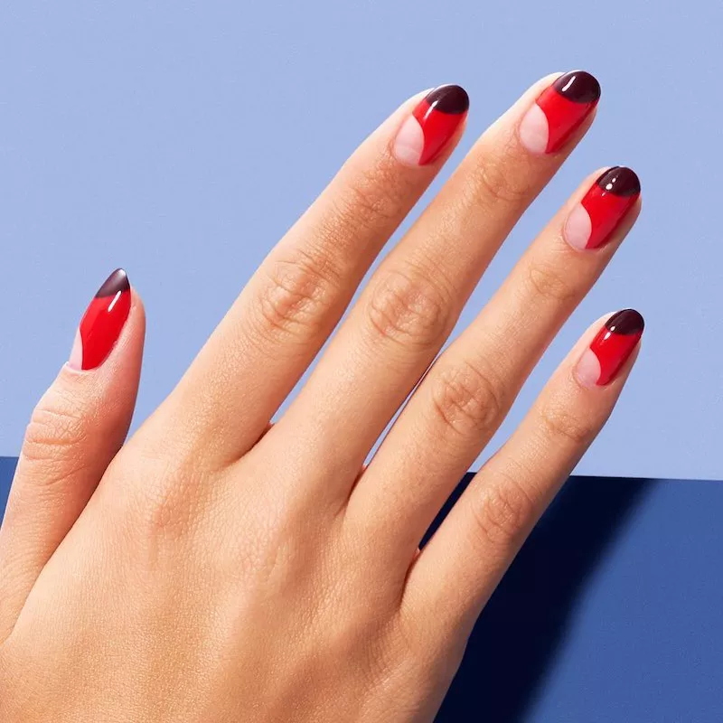 Rote Nägel mit negativem diagonalen Halbmond an der Nagelhaut und dunklem Halbmond an der Spitze